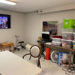 A functional indoor space featuring a table, chair, storage boxes, and a television.