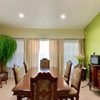 A spacious dining room with elegant wooden furniture and green walls.