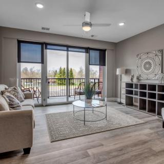 A modern living room with large patio doors, allowing natural light to illuminate the space decorated with contemporary furniture and neutral tones.