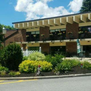 A modern architectural building surrounded by vibrant landscaping under a blue sky.