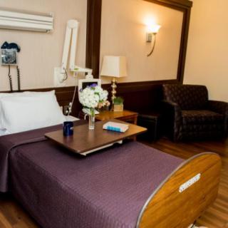 A well-appointed hospital room with a bed, medical equipment, and comfortable furnishings.