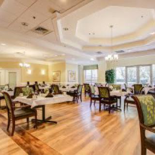 Elegant dining room with well-arranged tables and chairs, featuring warm lighting and a cozy atmosphere.