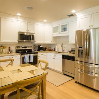 A modern kitchen with white cabinets and stainless steel appliances.