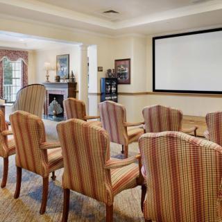 A conference room with arranged seating facing a large screen.