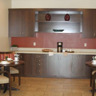 A modern kitchen and dining area featuring sleek wooden cabinetry and a cozy table setting.
