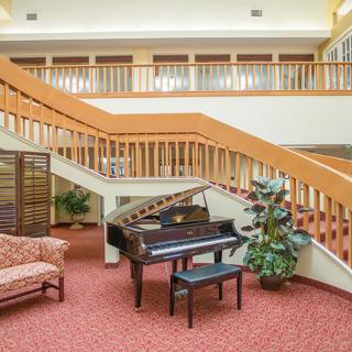 Elegant lobby with a grand piano and staircase.