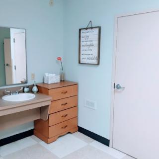 A clean and modern bathroom featuring a sink, mirror, and wooden storage unit.
