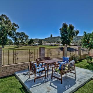 A scenic outdoor patio with a table and chairs overlooking a garden and trees.