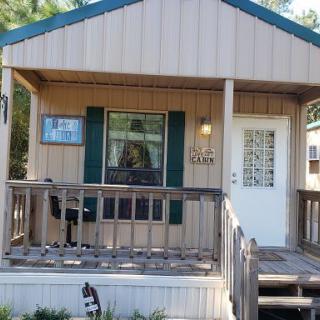 A quaint small house with a wooden porch and decorative elements.
