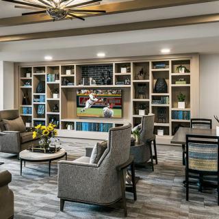 A modern living room with comfortable seating, bookshelves, and a television.