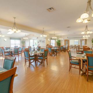 A spacious and well-lit dining room with neatly arranged tables and chairs.