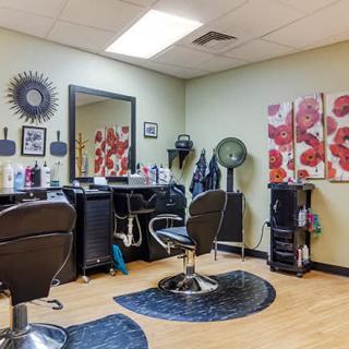 A cozy hair salon with styling stations and vibrant wall art.