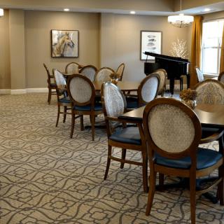 Elegantly designed dining area with tables, chairs, and a piano.
