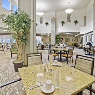 A spacious and well-lit dining area with neatly arranged tables and chairs.
