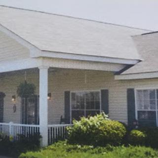 A charming residential home with a welcoming front porch and well-maintained landscaping.