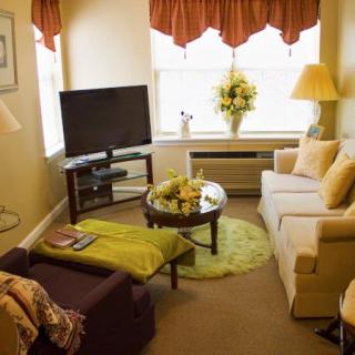 Cozy living room with a TV, sofa, and a floral centerpiece.
