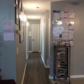 A home hallway with framed pictures and wooden flooring.