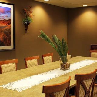 A well-decorated dining room with a long table, chairs, and wall art.