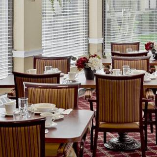 A cozy dining room with neatly arranged tables and chairs, ready for guests.
