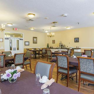 An elegantly furnished dining room featuring neatly arranged tables and chairs.