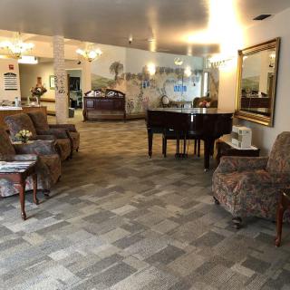 A spacious and elegantly decorated lobby featuring a grand piano, comfortable seating areas, and tasteful decor.