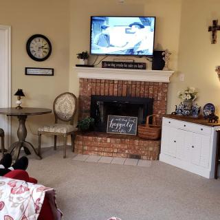 A cozy living room with a fireplace, TV, and comfortable seating arrangement.