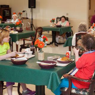 Residents enjoying a meal together in a communal dining area.