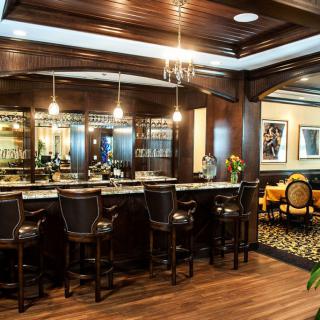 Luxurious bar interior with wooden decor and elegant seating.