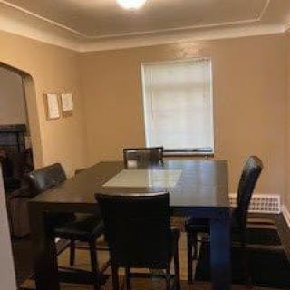A neatly arranged dining room with a table and chairs by the window.