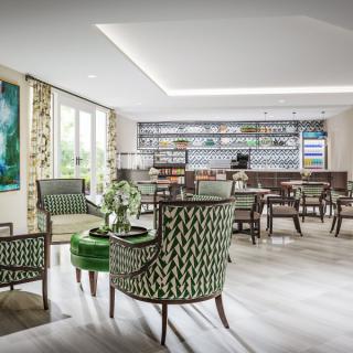 A modern lounge area with stylish seating and a bar in the background.