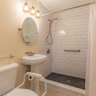 A modern bathroom with a shower area, sink, and toilet.