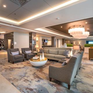 A modern and elegantly designed lobby with comfortable seating and a large chandelier.