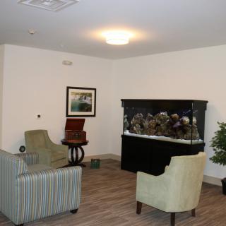 A cozy living room with an aquarium and seating arrangement.