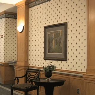 A well-decorated hallway featuring patterned wallpaper, a framed painting, and elegant furniture.