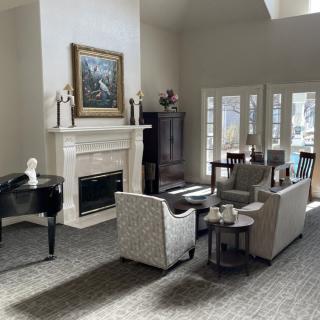 A stylish living room with a comfortable seating area and a fireplace, enhanced by natural light.