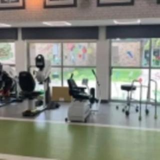 An indoor gym with various exercise equipment, likely used for rehabilitation and fitness training.