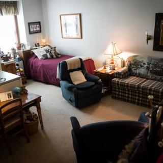 A cozy living room with a bed, sofa, and various furnishings.