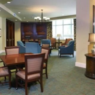 A comfortable lounge area featuring tables and chairs with warm lighting.