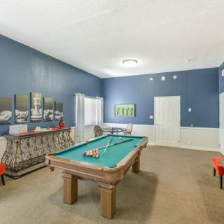 A cozy game room featuring a pool table and vibrant blue walls.