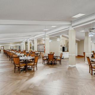 A spacious and well-lit dining area with wooden tables and chairs.