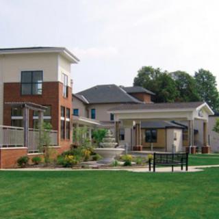 A modern residential building with a well-maintained garden and landscaping.