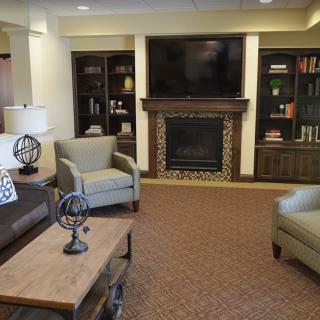 A cozy living room featuring a fireplace, television, and comfortable seating.