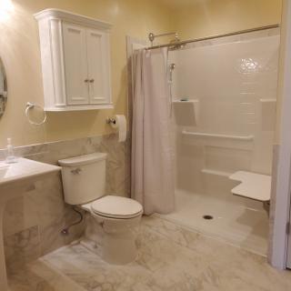 A neatly organized bathroom with a toilet, sink, and shower area.