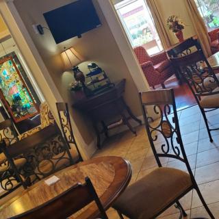 A cozy seating area with tables and chairs, featuring a television and decorative elements.