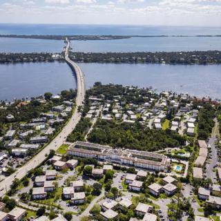 Aerial view of a bridge connecting to a residential area surrounded by water.