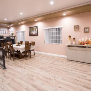 A spacious dining room with modern furnishings and warm lighting.