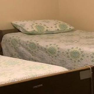 A bedroom with twin beds, each covered with patterned bedding and pillows.