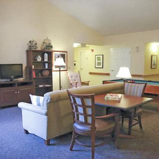 A cozy living room with a sofa, table, television, and bookshelf.