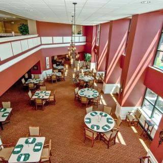 A spacious restaurant dining area with tables and chairs, featuring large windows providing ample natural light.
