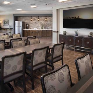 A modern conference room featuring a kitchenette and audiovisual equipment.